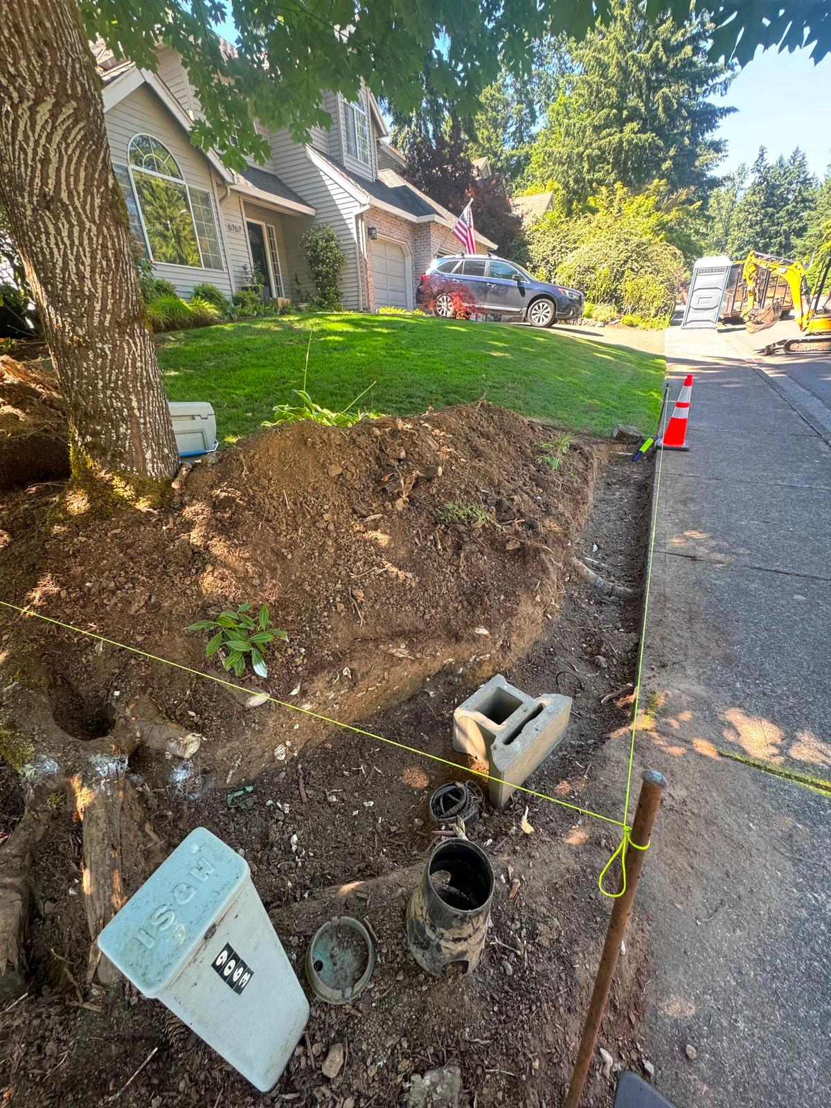 Front yard slope excavated along the sidewalk with string line set for a new retaining wall