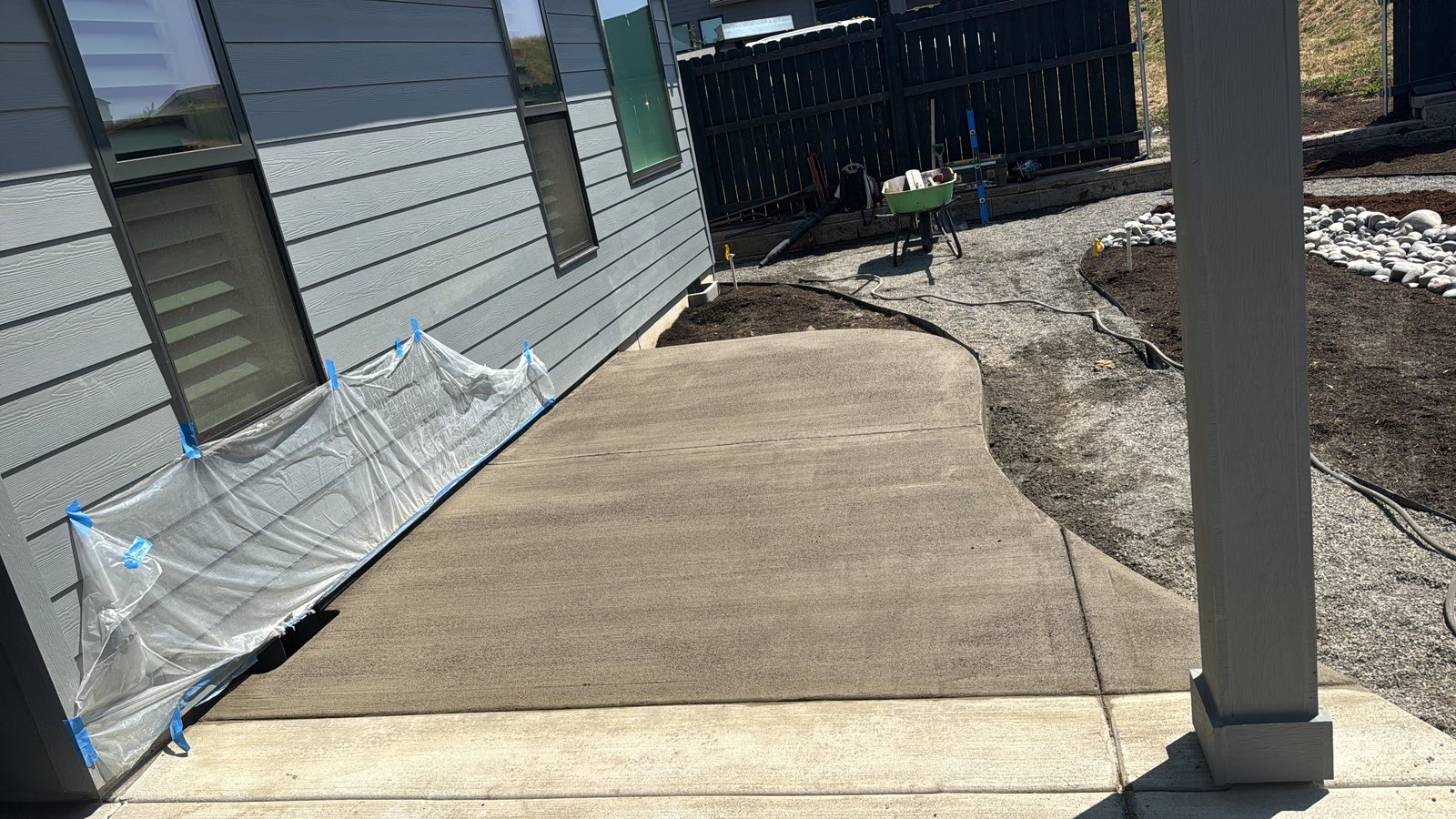 Poured concrete walkway running along the side of a home to the backyard